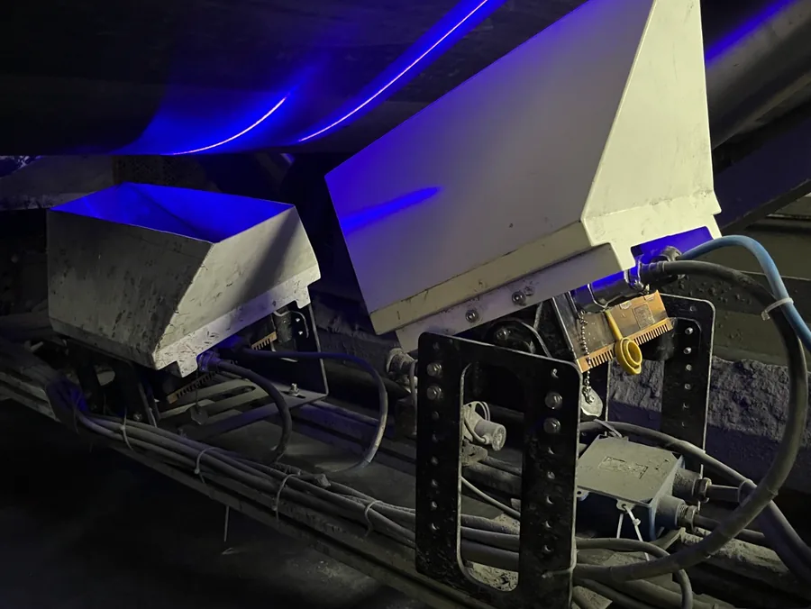 Cabeçote do sistema TDIS instalado sob uma correia transportadora, com feixe de laser azul